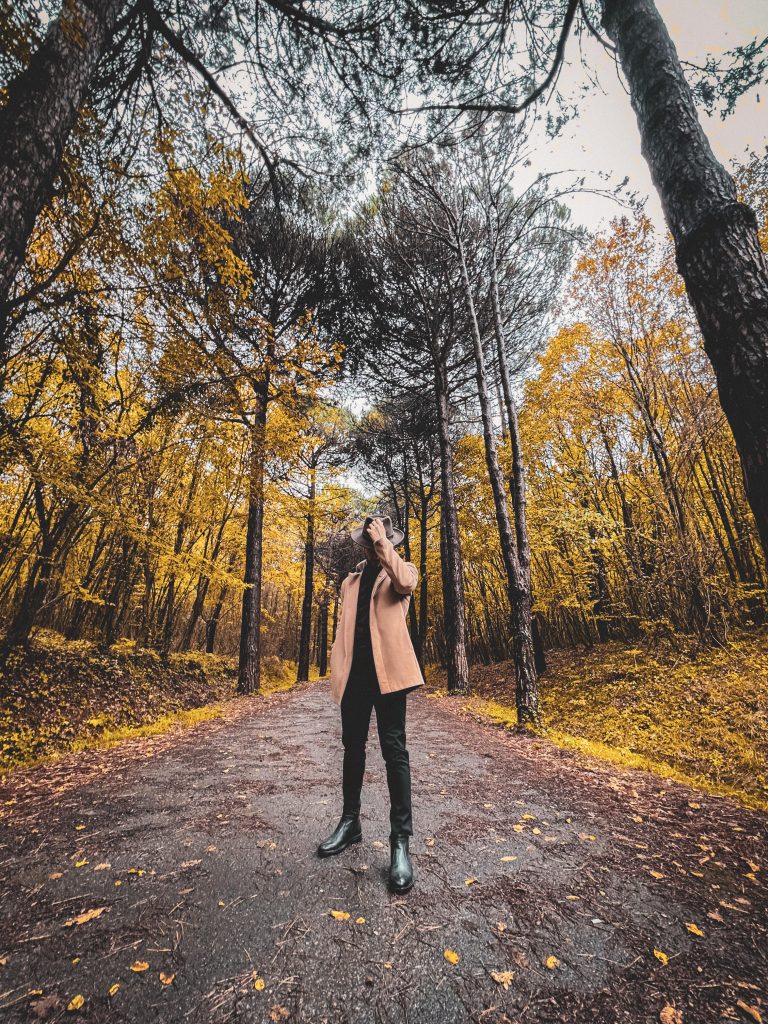 Atatürk Arboretumu’nda sonbahar yürüyüşü yapan bir ziyaretçi, orman yolunda poz veriyor